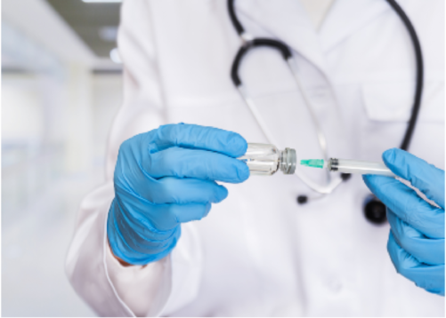 A doctor in blue surgical gloves preparing an allergen immunotherapy injection in a clinical setting