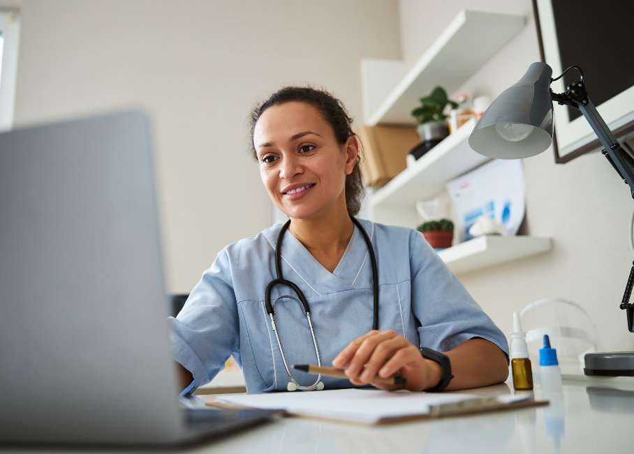 Healthcare provider smiling at her desk during a telehealth consultation