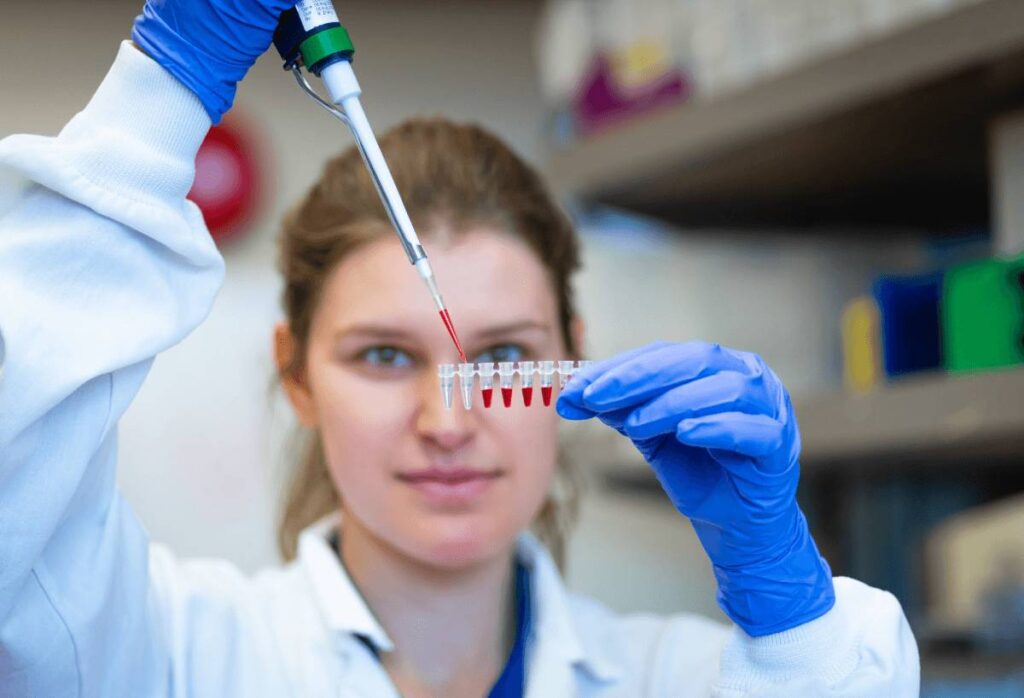 A researcher in a laboratory handling a syringe for injectable allergen immunotherapy (SCIT)